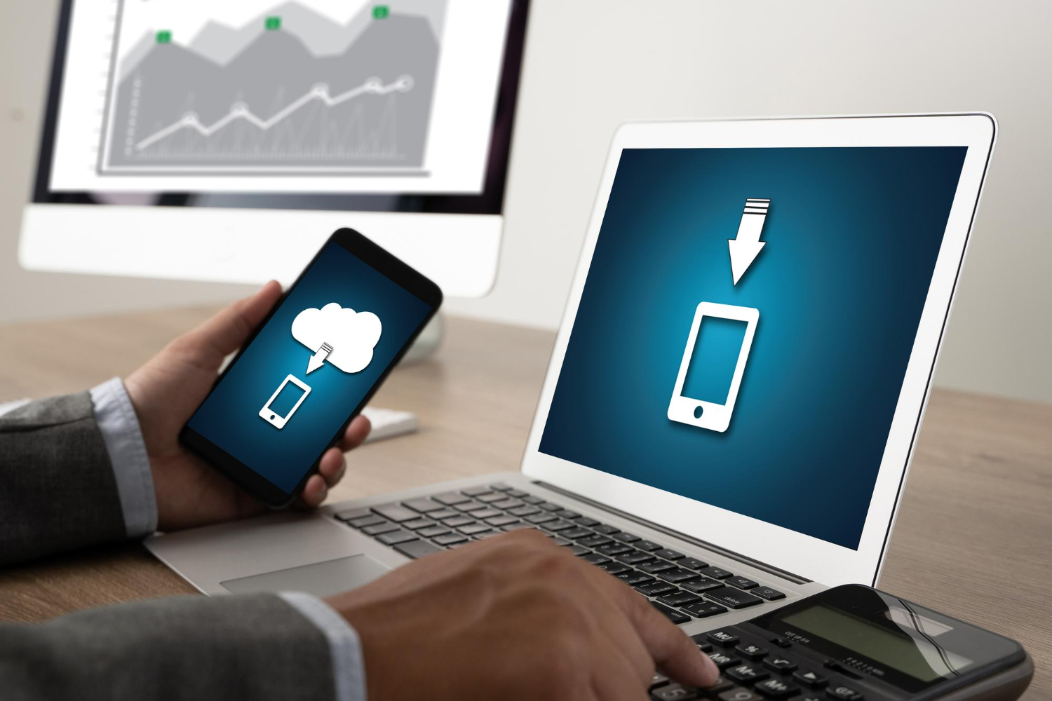 El hombre transfiere datos del teléfono a la computadora portátil